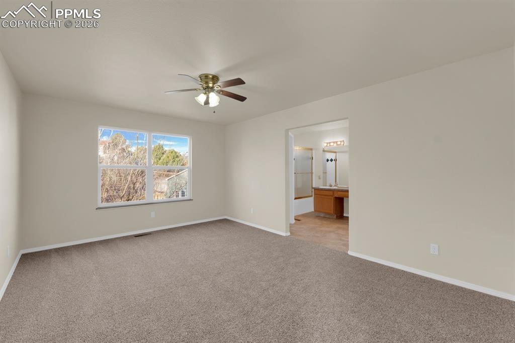 Image 14 of 41: Bedroom with light colored carpet and ceiling fan