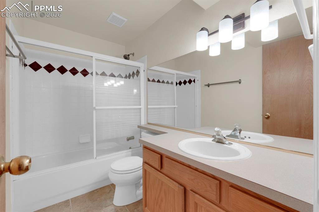 Image 23 of 41: Full bathroom featuring vanity, bath / shower combo with glass door, and li