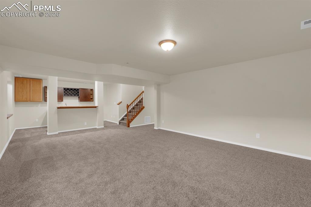 Image 25 of 41: Family room featuring carpet and wet bar with sink