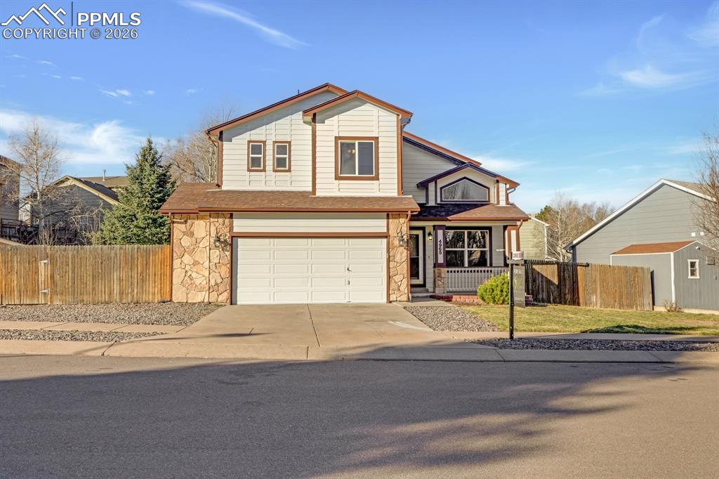 Image 6 of 41: Traditional home with driveway, an attached garage, and stone siding