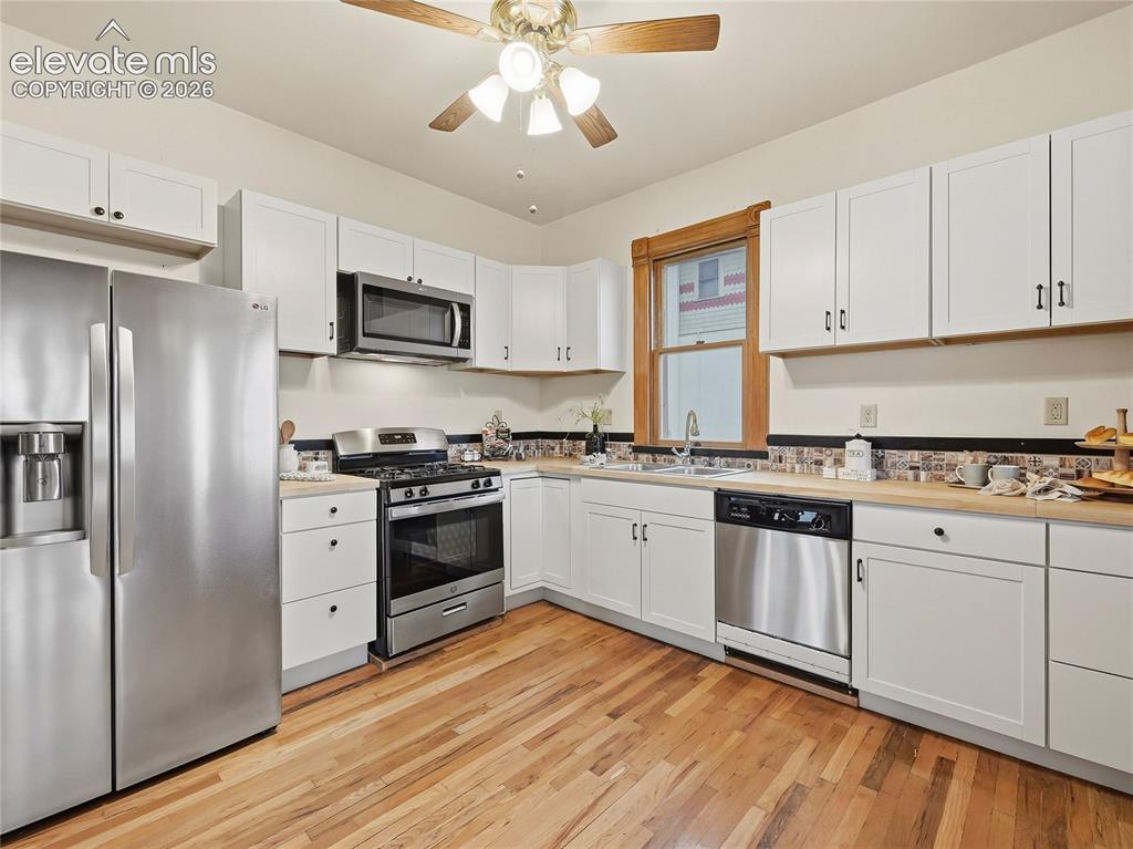 Image 12 of 33: Updated kitchen w/butcher block countertops and tile backsplash.