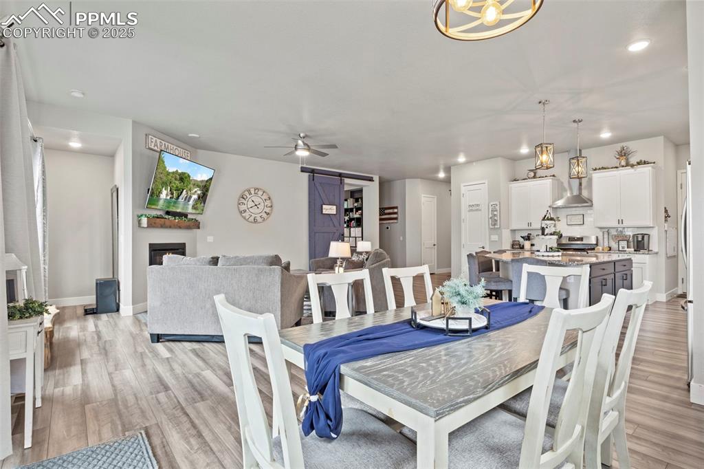 Image 11 of 38: Dining space featuring recessed lighting, a barn door, a ceiling fan, light
