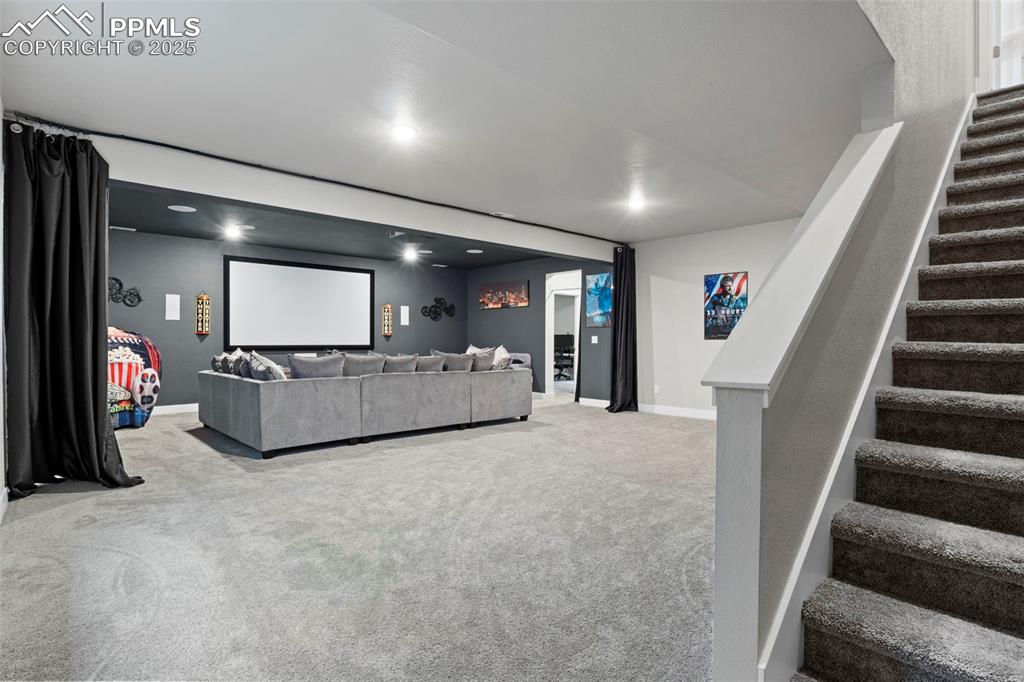 Image 18 of 38: Carpeted living room featuring baseboards, stairway, and recessed lighting