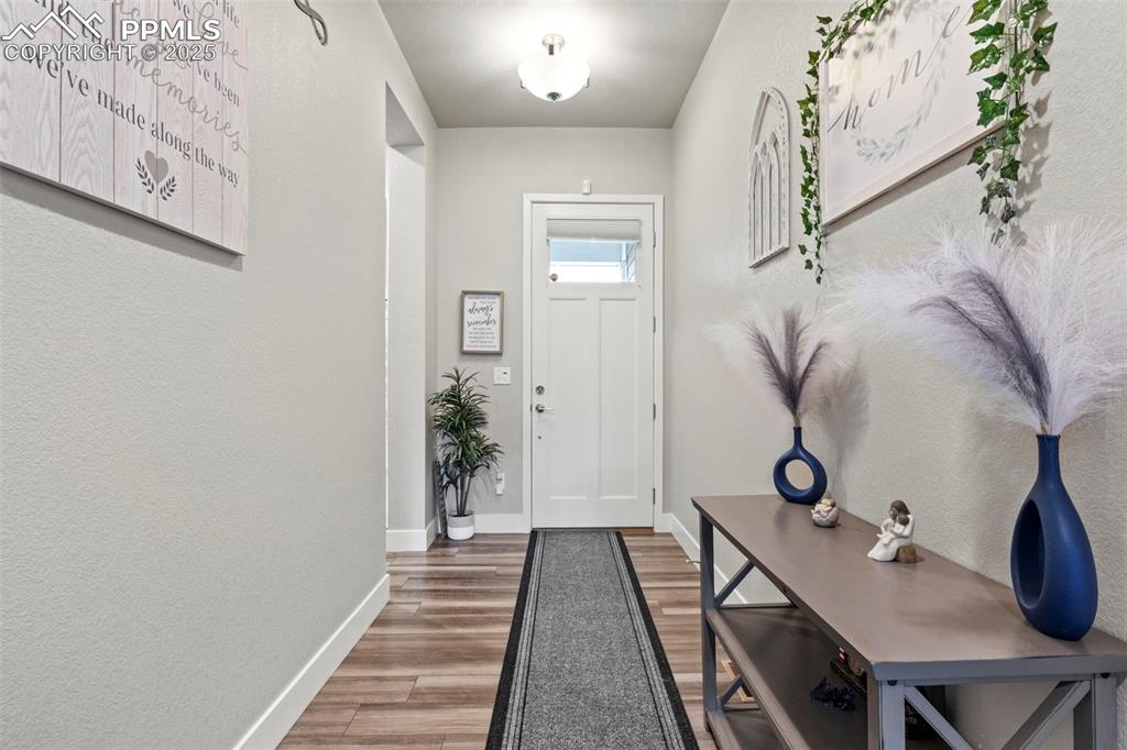 Image 2 of 38: Entryway with wood finished floors and baseboards