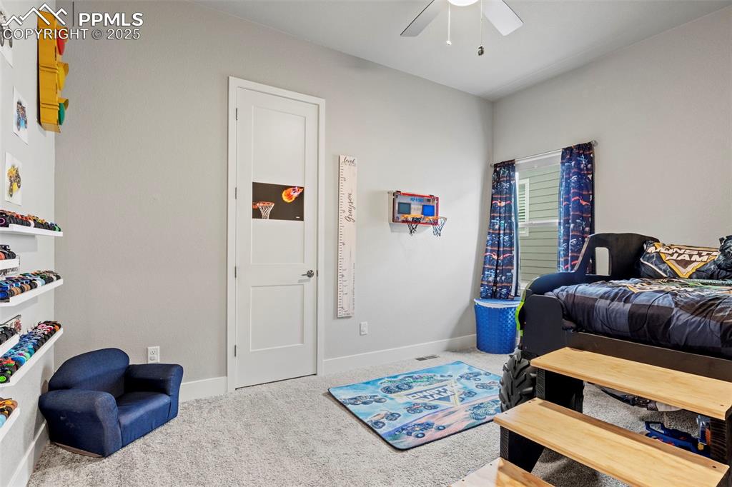Image 24 of 38: Carpeted bedroom with a ceiling fan and baseboards