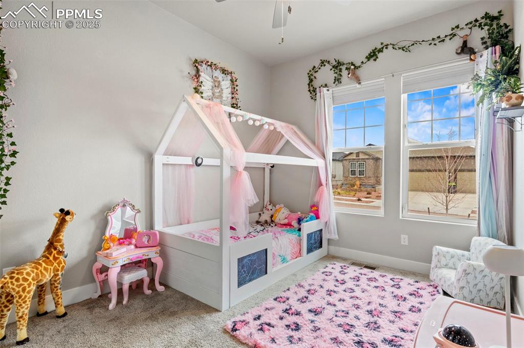 Image 27 of 38: Carpeted bedroom featuring baseboards, visible vents, and a ceiling fan