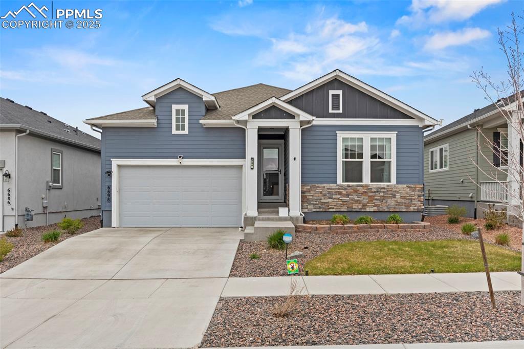 Image 36 of 38: View of front of home featuring stone siding, board and batten siding, conc