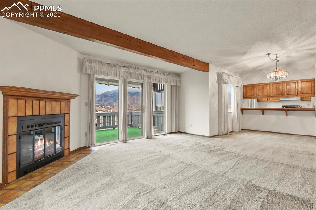 Image 7 of 35: Large Living Room with Wood Fireplace and Open to Covered Patio