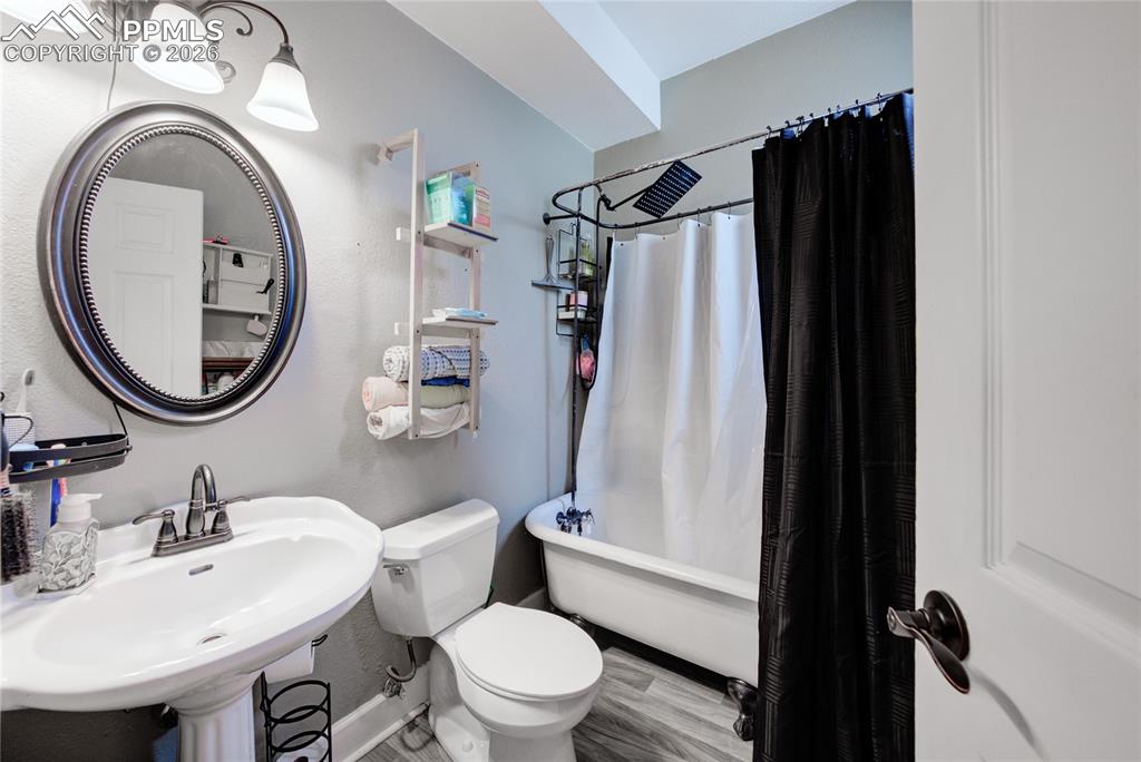 Image 5 of 33: lower unit bathroom at end of hall nearest 2nd bedroom