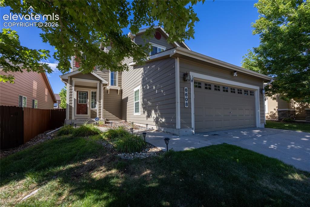 Image 2 of 39: The property features a two-story residence with light tan siding and white