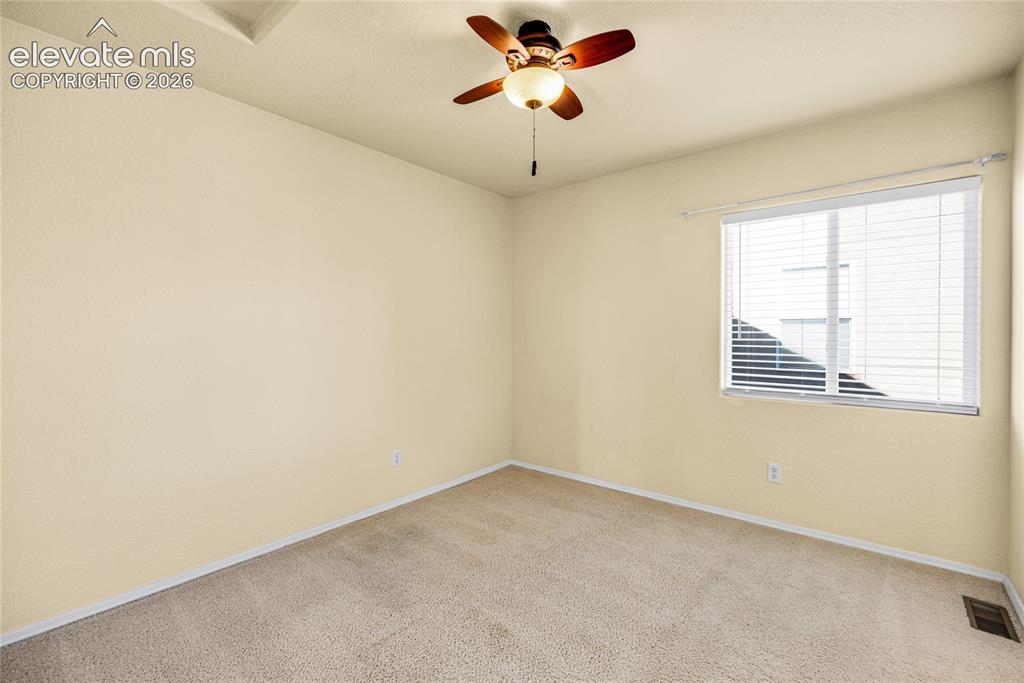 Image 21 of 39: Carpeted room with a ceiling fan, a window with horizontal blinds, and a fl