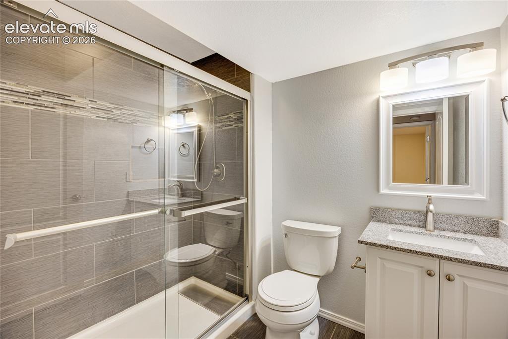 Image 27 of 39: Walk-in shower with clear glass enclosure and gray tile surround featuring 