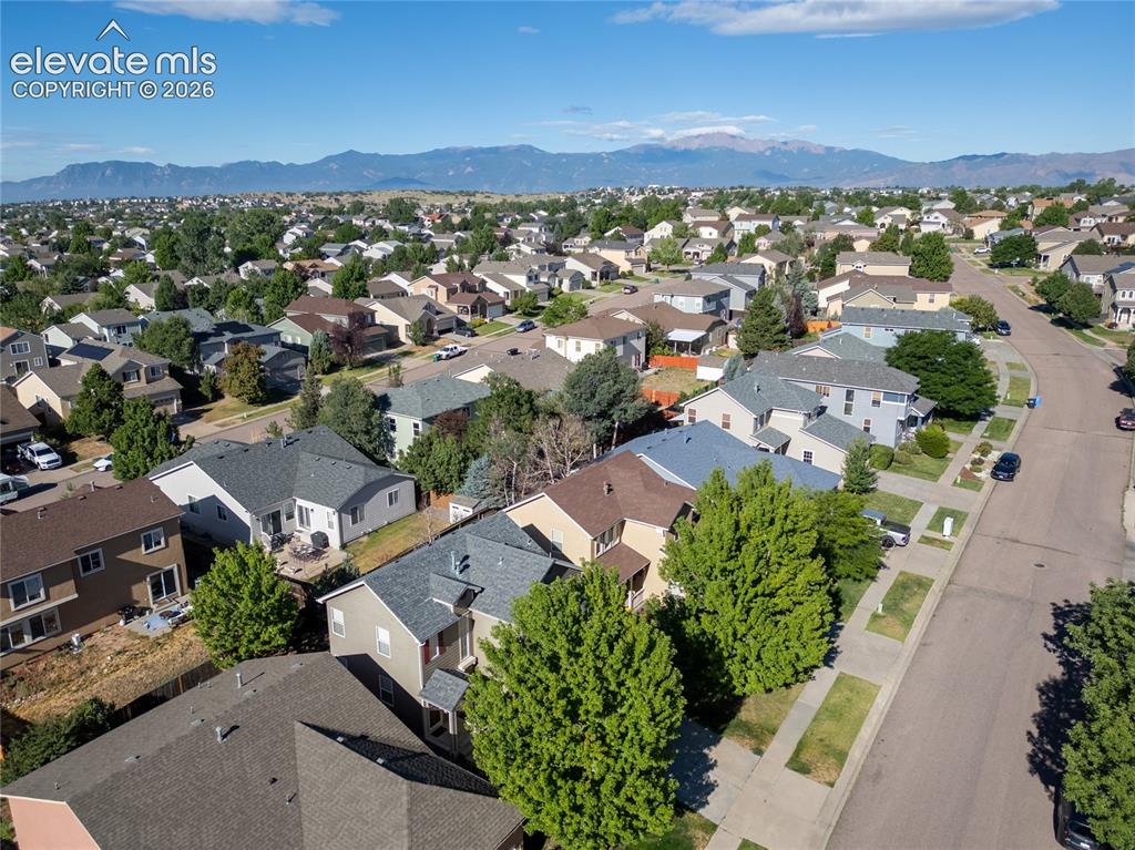 Image 35 of 39: Expansive neighborhood with a mountainous backdrop under a clear blue sky