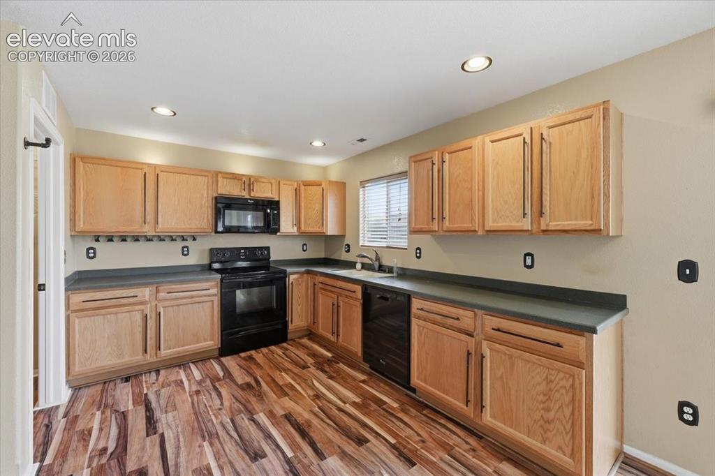 Image 10 of 26: Kitchen featuring wood-finish flooring, recessed lighting, wood cabinetry,