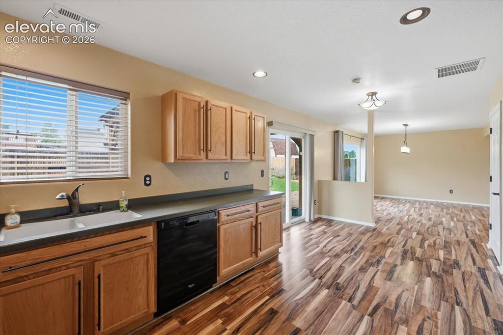 Image 11 of 26: Warm wood-finish flooring throughout, light wood cabinetry, recessed lighti