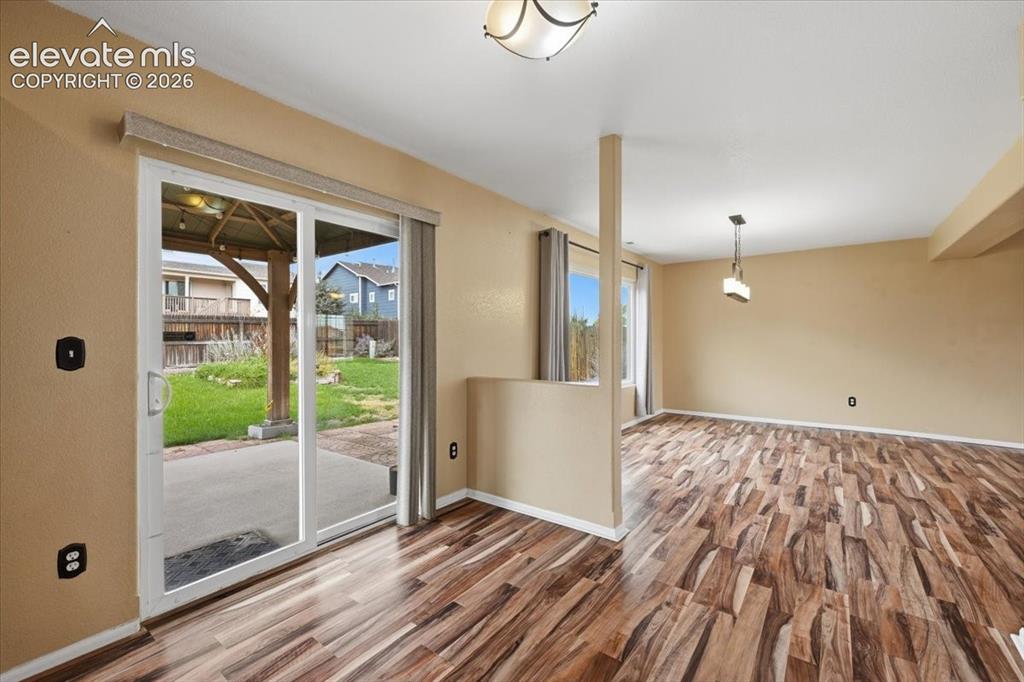 Image 12 of 26: Wood-finish flooring, sliding glass door, recessed lighting, and a contempo