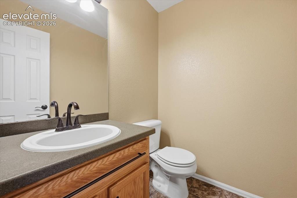 Image 14 of 26: Vanity with a white oval sink, dark bronze-finish faucet, and wood-finish c