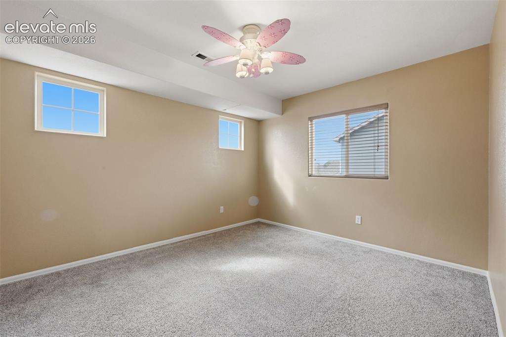 Image 15 of 21: Carpeted flooring, multiple windows, a ceiling-mounted fan with integrated 