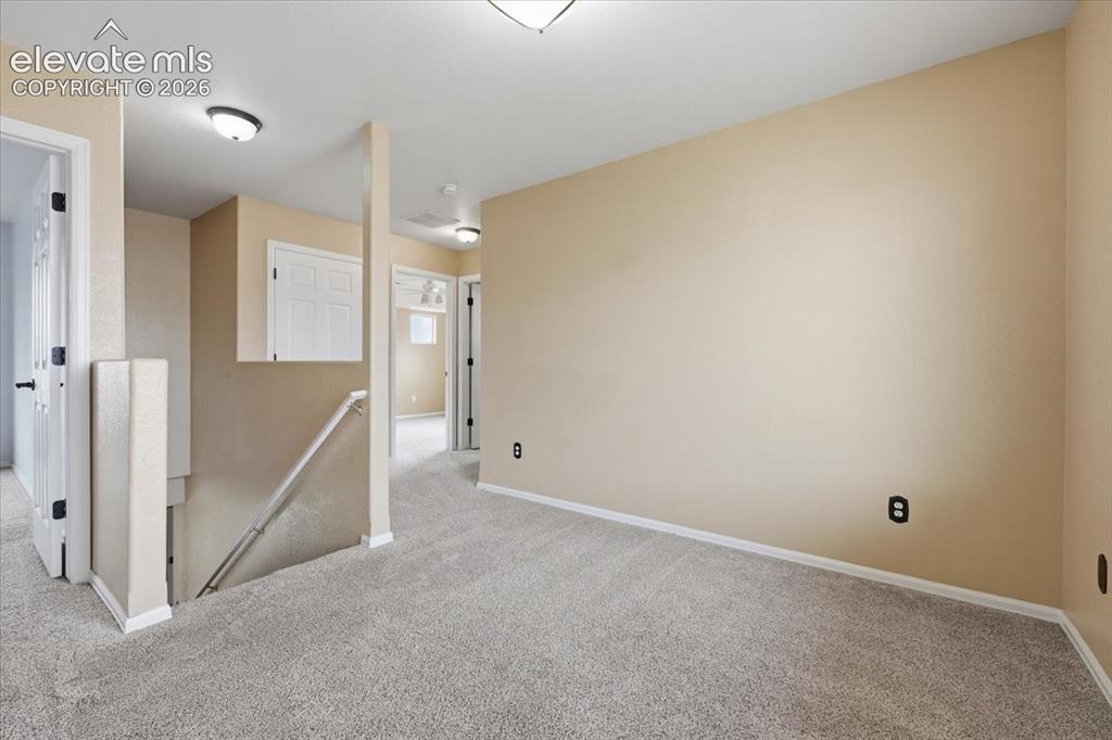 Image 15 of 26: Neutral-toned walls complement the gray carpeting
