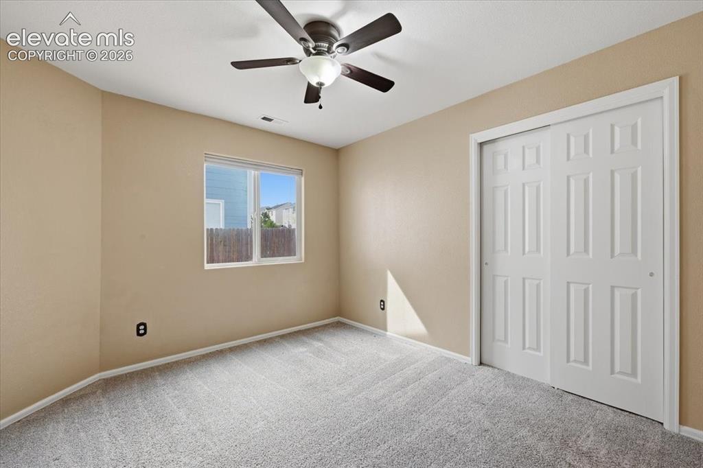 Image 16 of 26: Recessed window, paneled bi-fold closet doors, ceiling fan with integrated