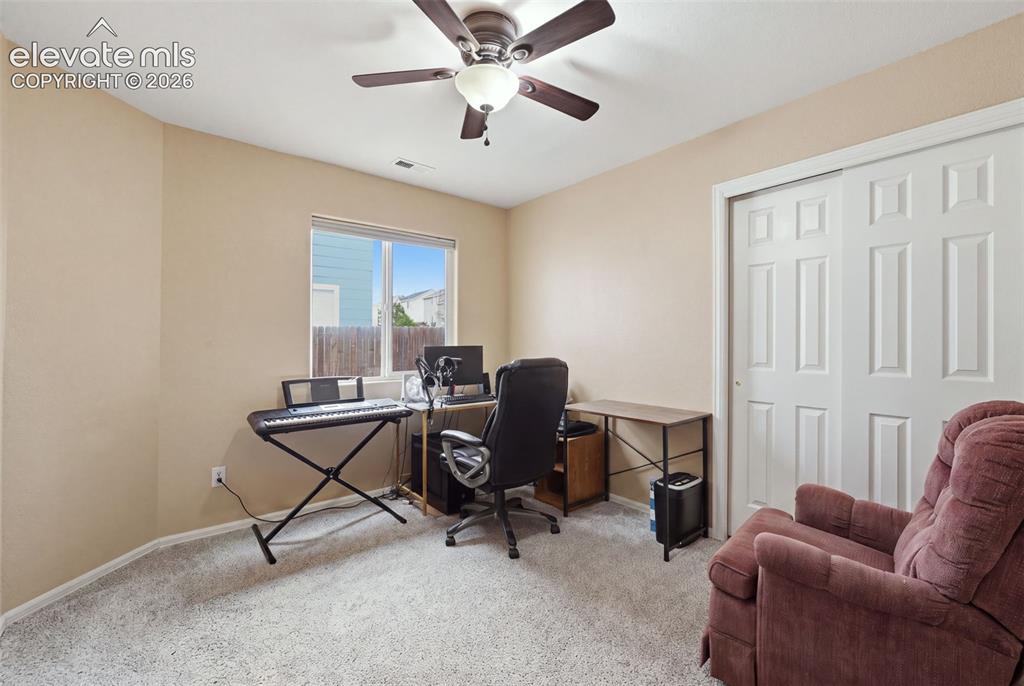 Image 21 of 21: Carpeted room with a ceiling fan, a window, and a bi-fold closet door