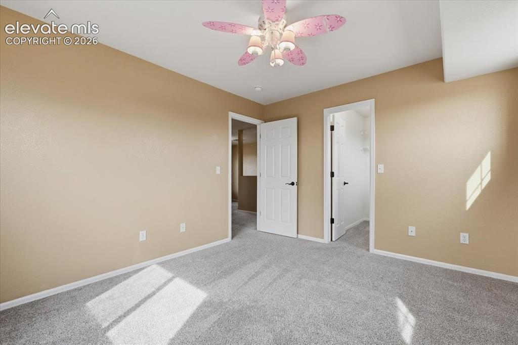 Image 23 of 26: Light gray carpeting, beige wall paint, white trim, and white doors with bl