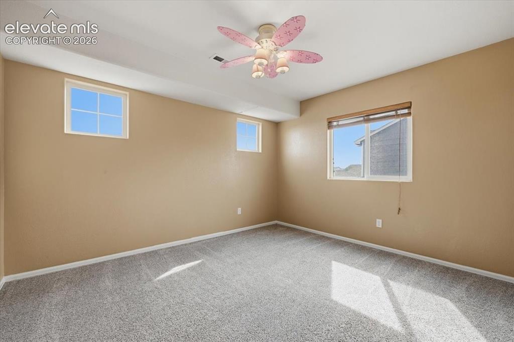 Image 24 of 26: Carpeted flooring, multiple windows, ceiling fan with integrated lighting,