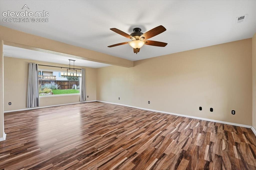 Image 4 of 26: Wood-finish flooring throughout, complemented by a ceiling fan with integra