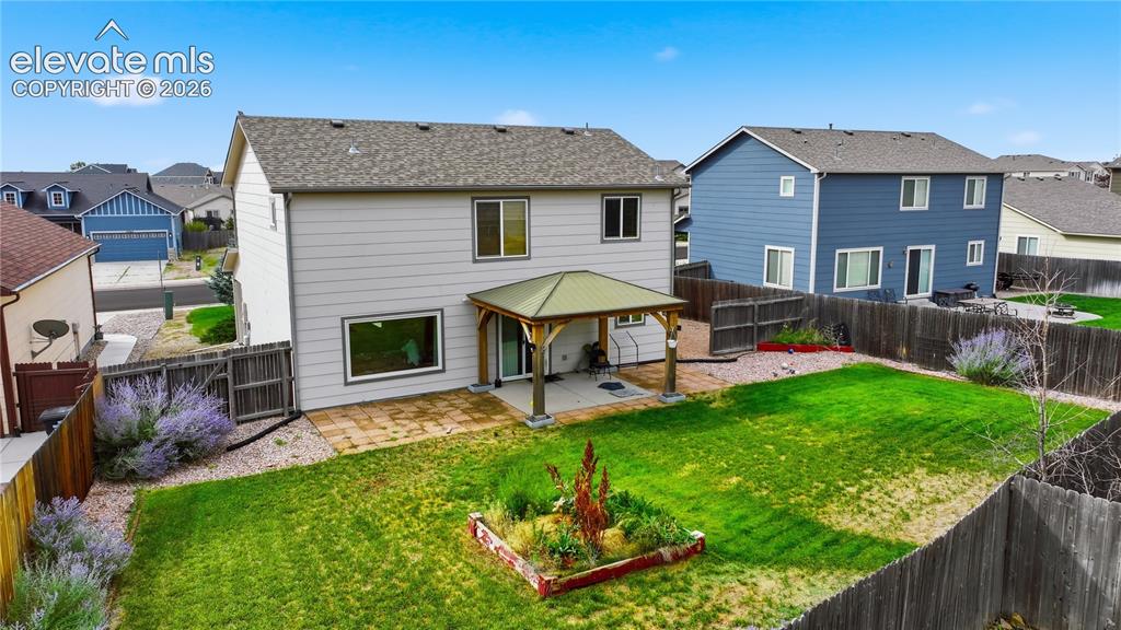 Image 5 of 21: Expansive backyard featuring a manicured lawn, established landscaping, and