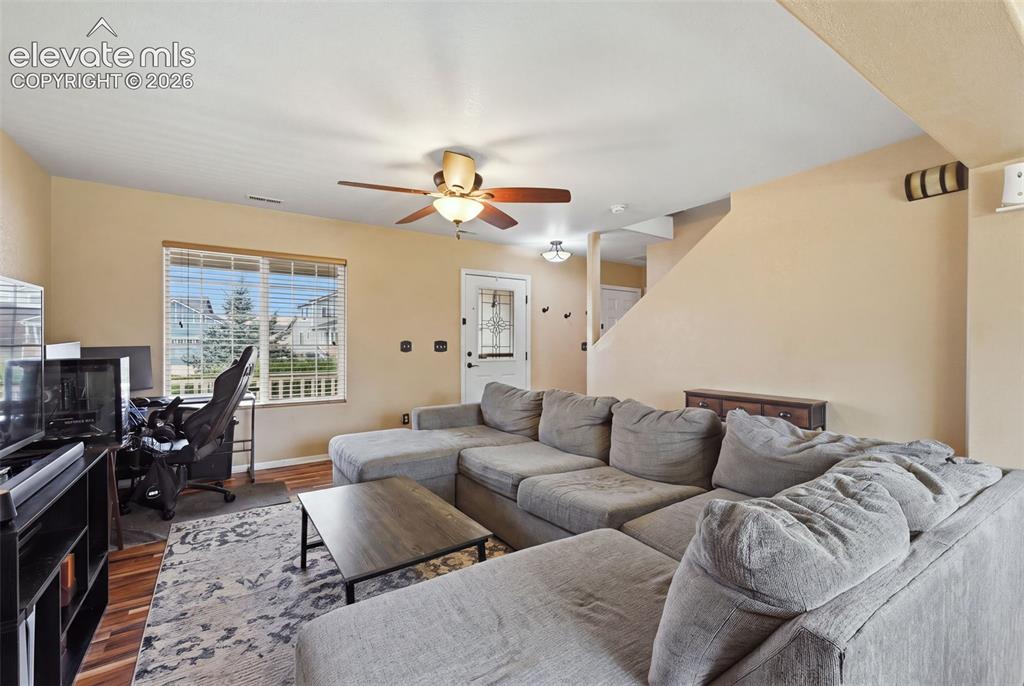 Image 6 of 21: Hardwood-finish flooring, recessed lighting, ceiling fan, and built-in shel