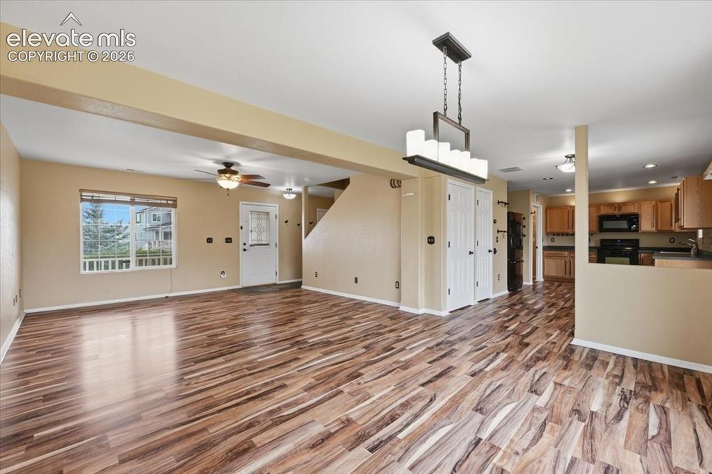Image 7 of 26: Open concept living area featuring wood-finish flooring, a modern chandelie