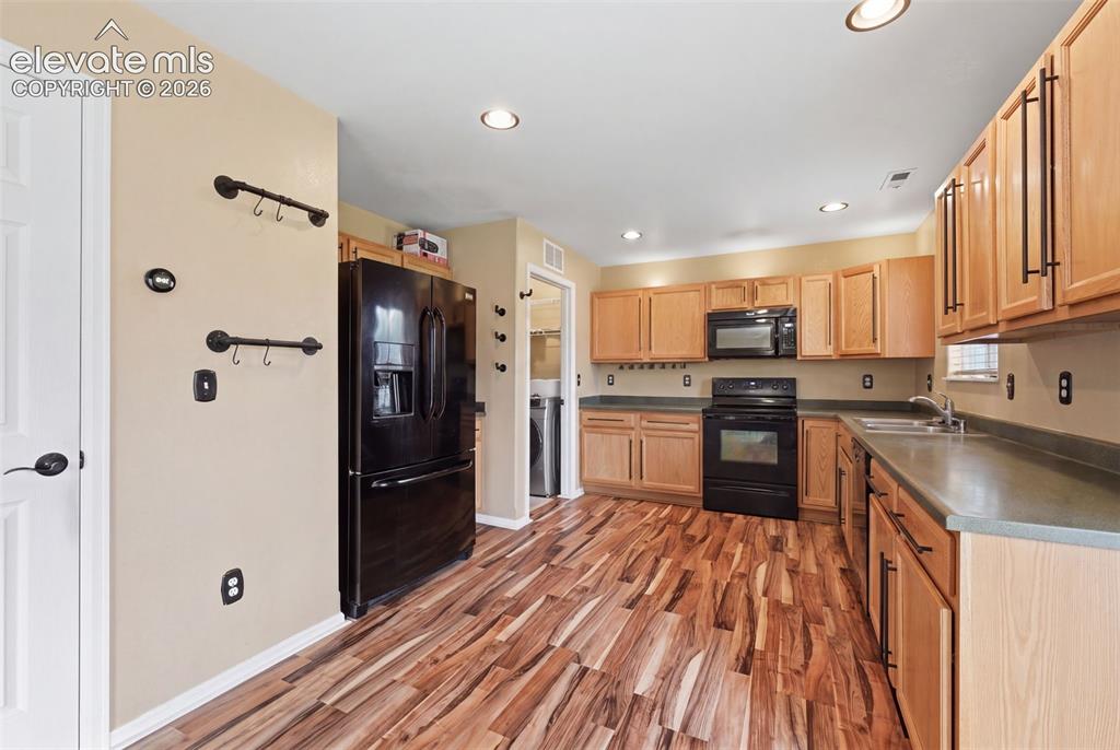 Image 8 of 21: Kitchen featuring wood-finish flooring, recessed lighting, wood cabinetry,