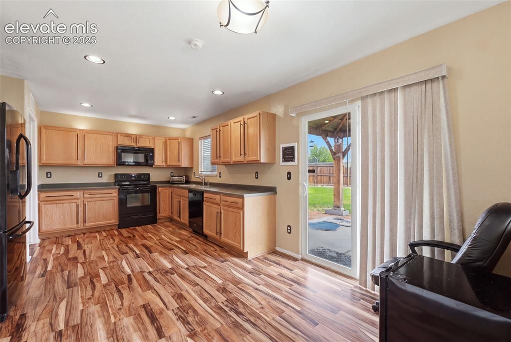 Image 9 of 21: Kitchen featuring wood-finish flooring, recessed lighting, wood cabinetry, 