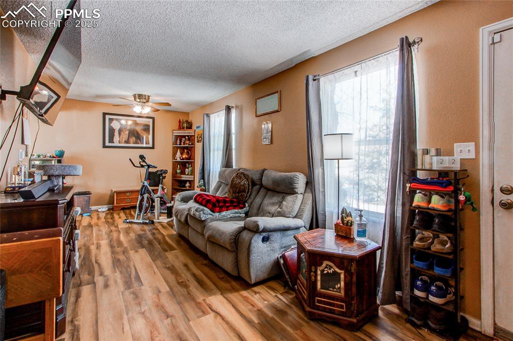Image 4 of 36: Living room featuring hardwood / wood-style flooring, ceiling fan, and a te