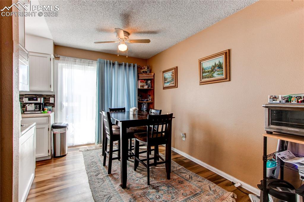 Image 7 of 36: Dining area with ceiling fan, light hardwood / wood-style flooring, and a t