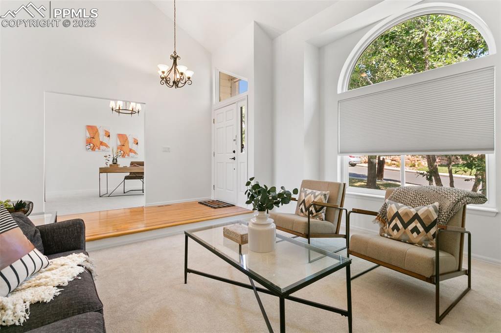 Image 11 of 50: Living room with light carpet, a chandelier, light wood-type flooring, and 