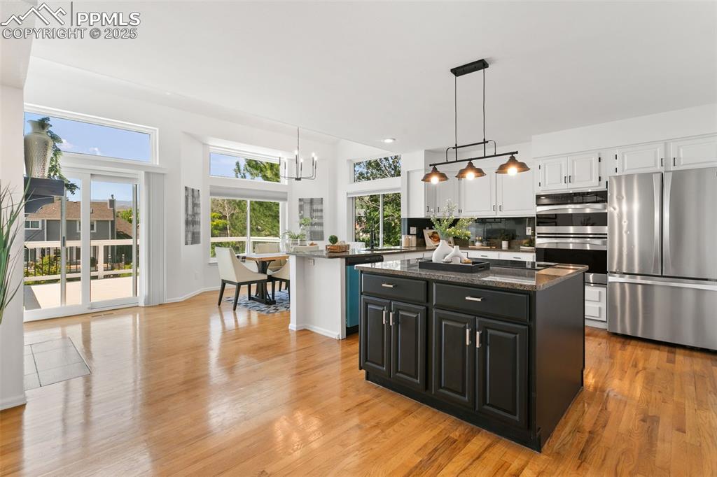 Image 13 of 50: Kitchen featuring stainless steel appliances, white cabinets, a kitchen isl
