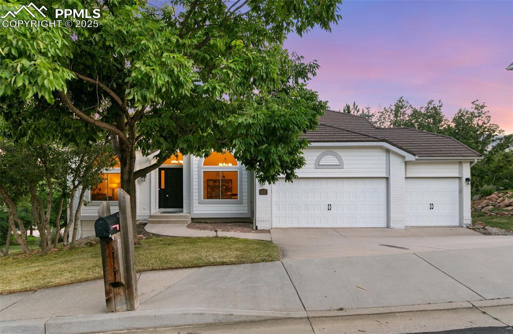 Image 2 of 50: View of front of property with an attached garage, concrete driveway, brick