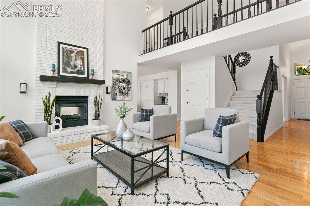 Image 20 of 50: Living area featuring wood finished floors, a high ceiling, stairs, and a b