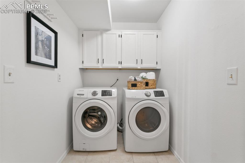 Image 23 of 50: Laundry area featuring cabinet space, independent washer and dryer, and lig