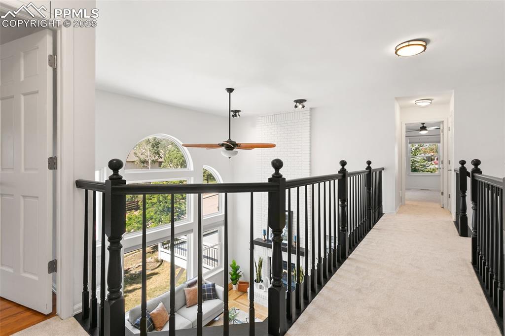 Image 25 of 50: Hall with an upstairs landing and carpet flooring
