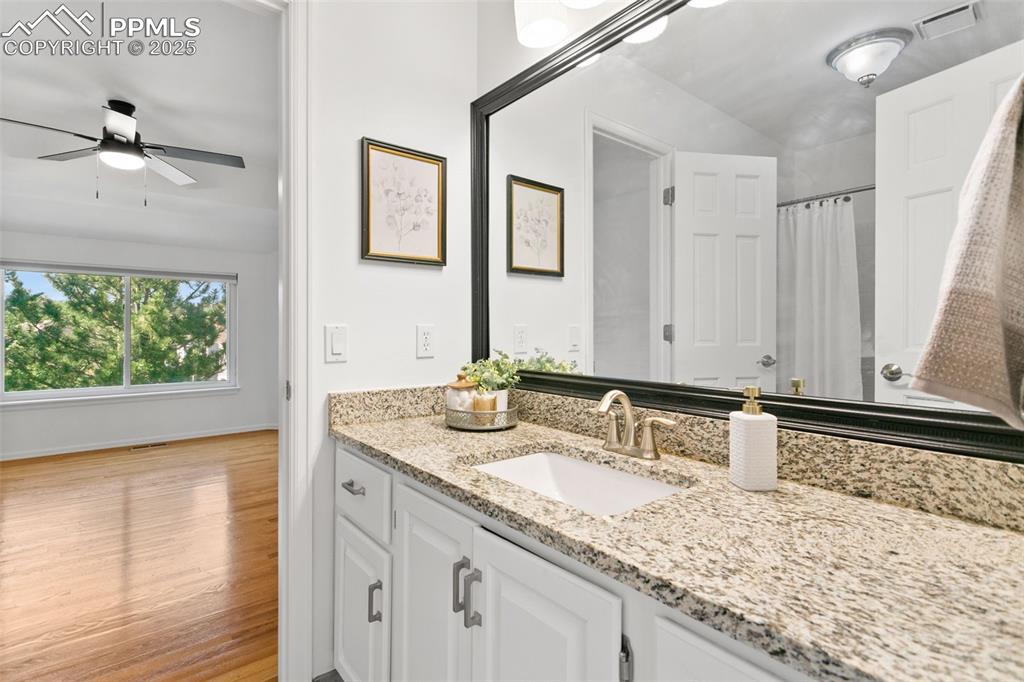 Image 30 of 50: Bathroom with vanity, wood finished floors, and a shower with curtain