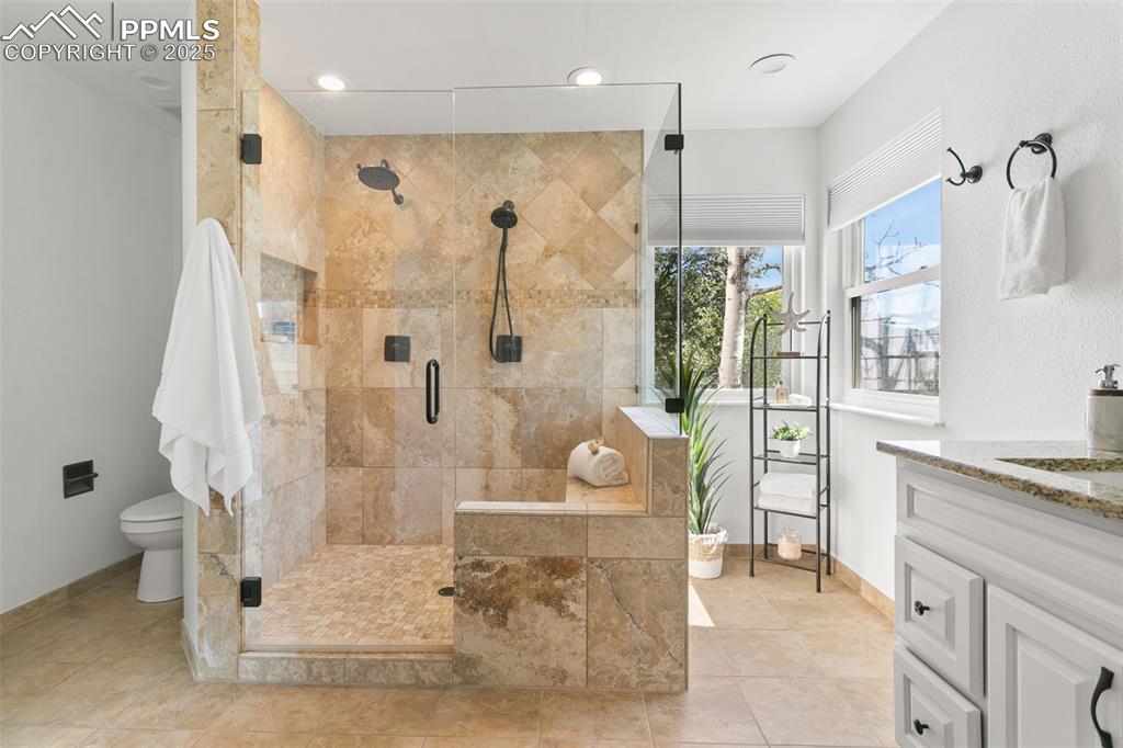 Image 35 of 50: Full bathroom featuring vanity, a shower stall, tile patterned flooring, an