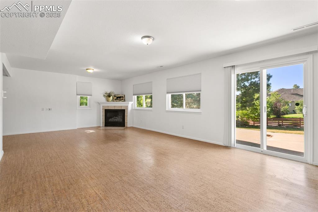 Image 38 of 50: Unfurnished living room featuring a tile fireplace and baseboards