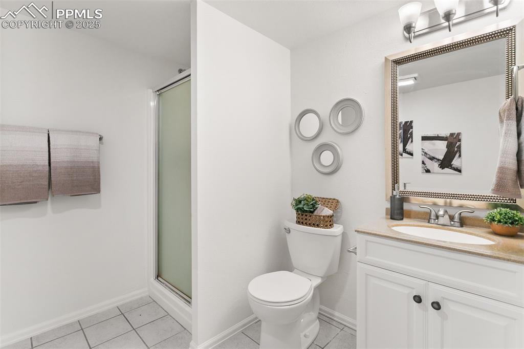Image 42 of 50: Full bath featuring tile patterned flooring, vanity, and a stall shower
