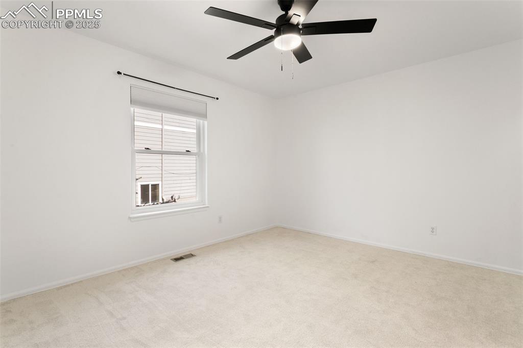 Image 46 of 50: Empty room with carpet flooring and a ceiling fan
