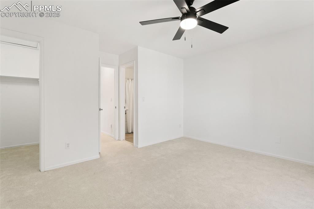 Image 47 of 50: Unfurnished bedroom featuring light carpet, ceiling fan, and a spacious clo