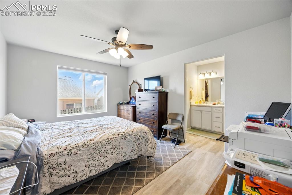 Image 12 of 46: Bedroom featuring light wood-style flooring, a ceiling fan, and ensuite bat