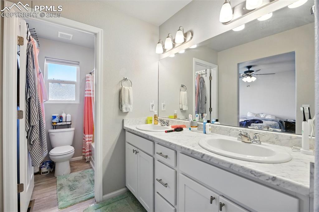 Image 15 of 46: Ensuite bathroom with double vanity, light wood-style flooring, shower / ba