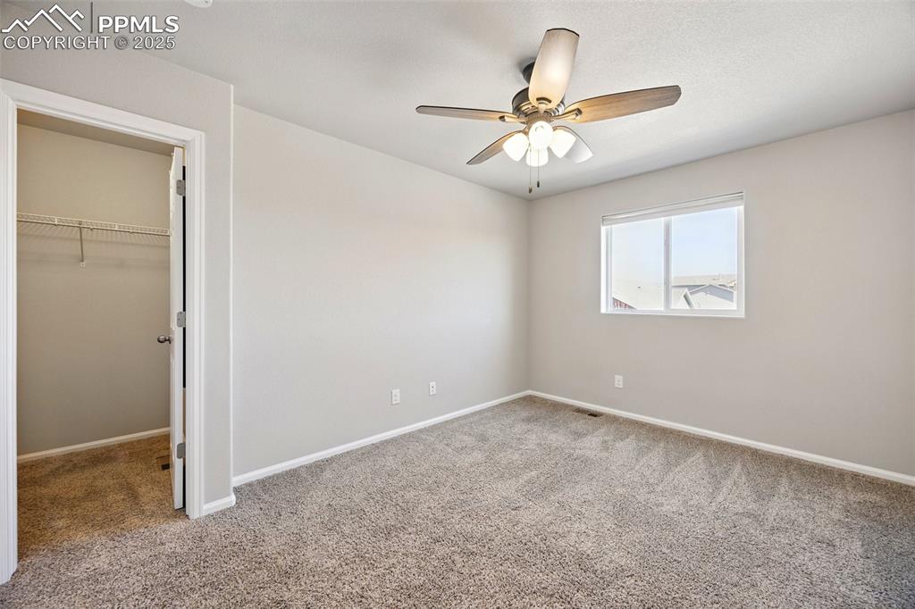 Image 18 of 46: Unfurnished bedroom featuring carpet, a walk in closet, and ceiling fan
